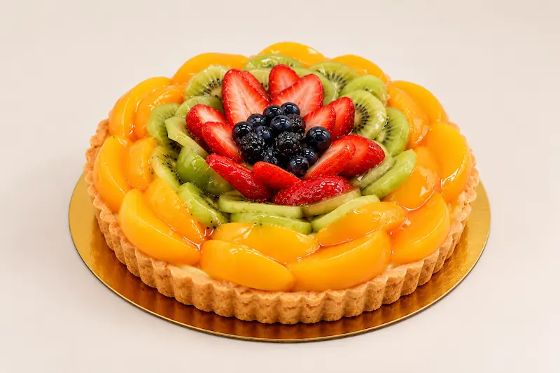 Glazed fruit tart ringed with peach, kiwi, strawberries and berries
